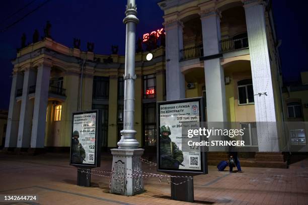 Posters promoting contract army service sit on a square outside the railway station in Voronezh on June 27, 2023. Bomb craters, shelled homes,...