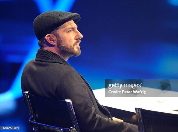Jury member Mirko Bogojevic listens to a performance during 'The X Factor Live' Semifinal TV-Show on November 29, 2011 in Cologne, Germany.