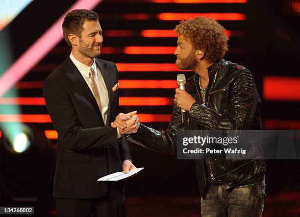Host Jochen Schropp and Rufus Martin shake hands during 'The X Factor Live' Semifinal TV-Show on November 29, 2011 in Cologne, Germany.