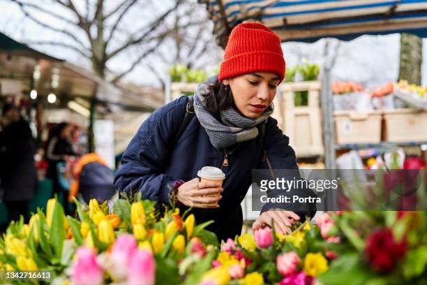 joven comprando flores en el mercado local - berlin cafe fotografías e imágenes de stock