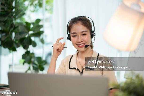 happy girl interpreter in headset write notes study on laptop - übersetzung stock-fotos und bilder
