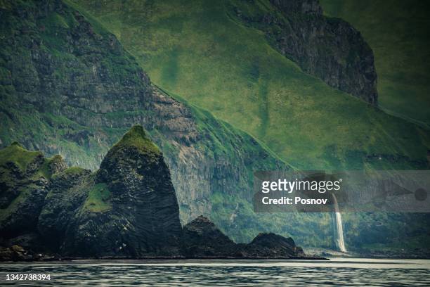 sea cliffs and waterfall of unalaska, - alaska coastline stock pictures, royalty-free photos & images