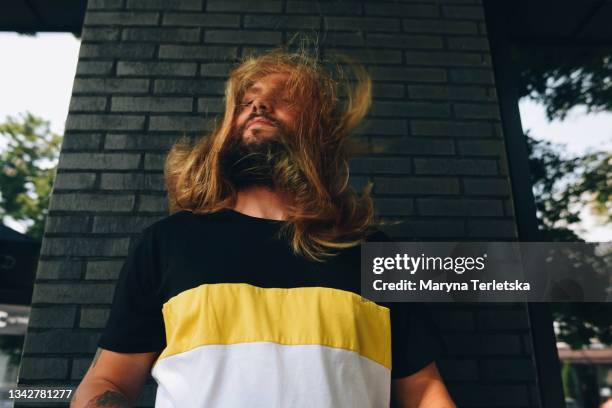 portrait of a young guy with long hair and a beard. - ruffled hair stock pictures, royalty-free photos & images