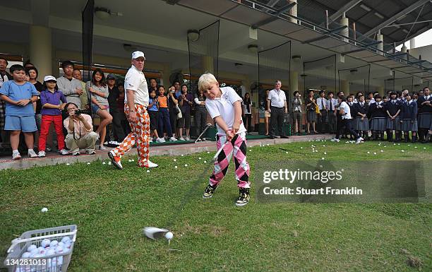 John Daly son of golfer John Daly of USA hits a ball as he is watched by pupils from local schools during a golf clinic prior to the start of the UBS...