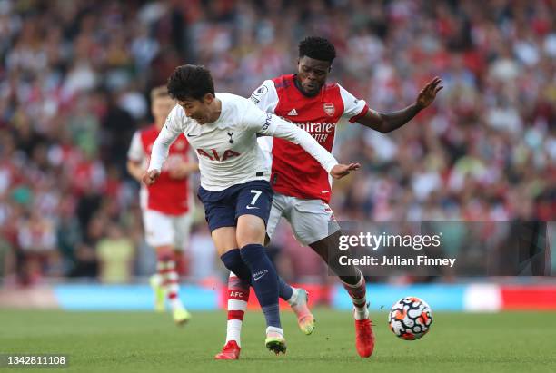 Heung-Min Son of Tottenham Hotspur is challenged by Thomas Partey of Arsenal during the Premier League match between Arsenal and Tottenham Hotspur at...