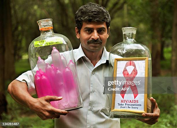 Indian glass artist Basavarju S. Gowda displays his creation of placing inflated condoms and a picture frame coveying 'safe sex' message inside glass...