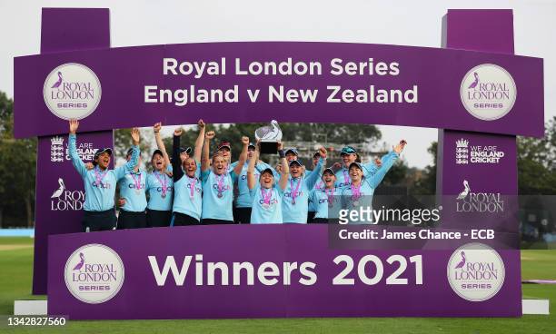 Heather Knight of England lifts the trophy as she celebrates victory in the series with her team mates after the 5th One Day International match...