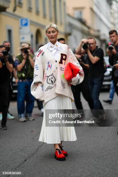 Guest wears black hair clips, a white shirt with gold brooch from Philosophy, a white latte with black and neon colors embroidered pattern oversized...