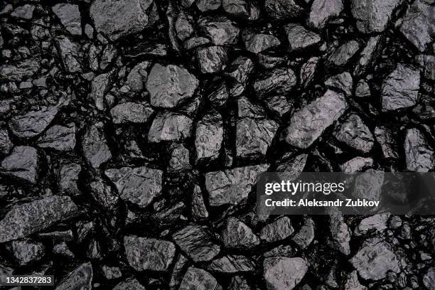 gray or black gravel or crushed stone for road construction and reconstruction, poured with bitumen. preparation and laying of asphalt. textured background. construction industry. - asphalt stock pictures, royalty-free photos & images