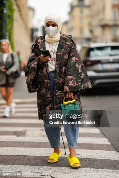 Guest wears a white scarf, a white with embroidered green and red tennis pattern t-shirt from Gucci, a khaki / beige / black / brown military print...