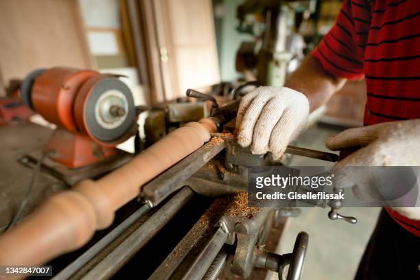 man shaping wood with a lathe in his carpentry workshop - wood shaving stock pictures, royalty-free photos & images
