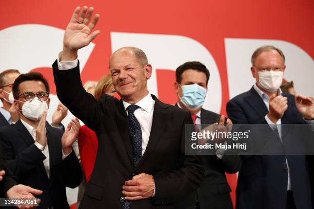 Olaf Scholz, chancellor candidate of the German Social Democrats , waves to supporters in reaction to initial results at SPD headquarters in federal...
