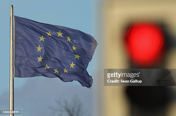 Flag of the European Union waves in the wind near a traffic light showing red on November 30, 2011 in Berlin, Germany. Many European leaders are...