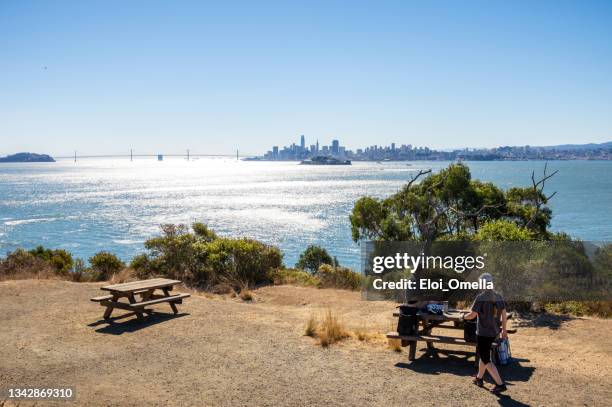 tourists in angel island with alcatraz island and san francisco in the background - angel island stock pictures, royalty-free photos & images