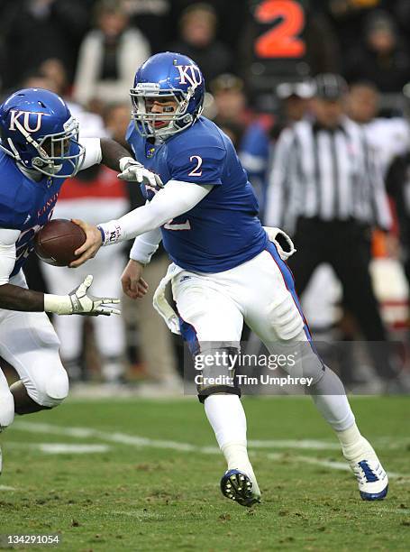 Quarterback Jordan Webb of the Kansas Jayhawks hands off to the running back in a game against the Missouri Tigers at Arrowhead Stadium on November...