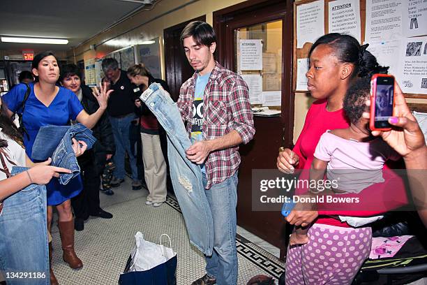 Naomi Hirabayashi and Justin Long hand out jeans at a womens shelter during the 'DoSomething.org Re-launches As A Membership-based Organization With...