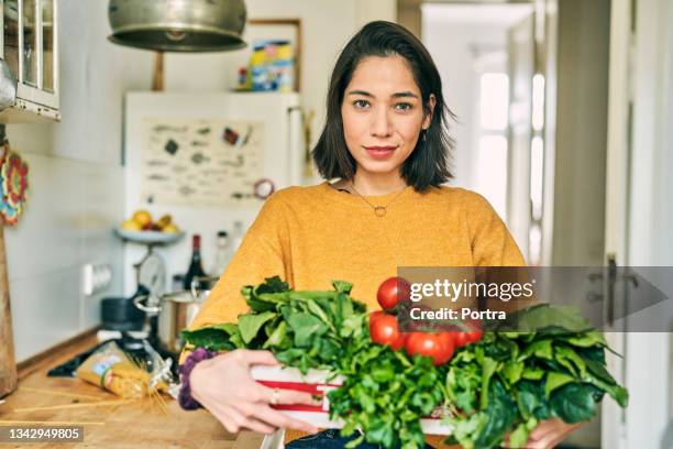 young woman with box full of groceries at home - feeling full stock pictures, royalty-free photos & images