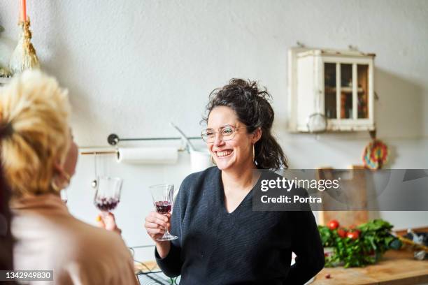 frau mit freunden beim wein zu hause - freundinnen wein stock-fotos und bilder