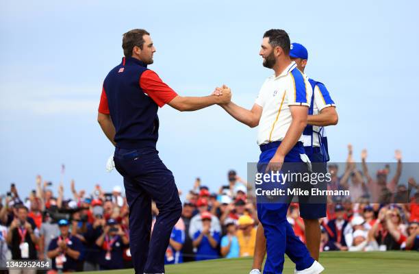 Scottie Scheffler of team United States and Jon Rahm of Spain and team Europe shake hands on the 15th green after Scheffler defeated Rahm 4&3 during...