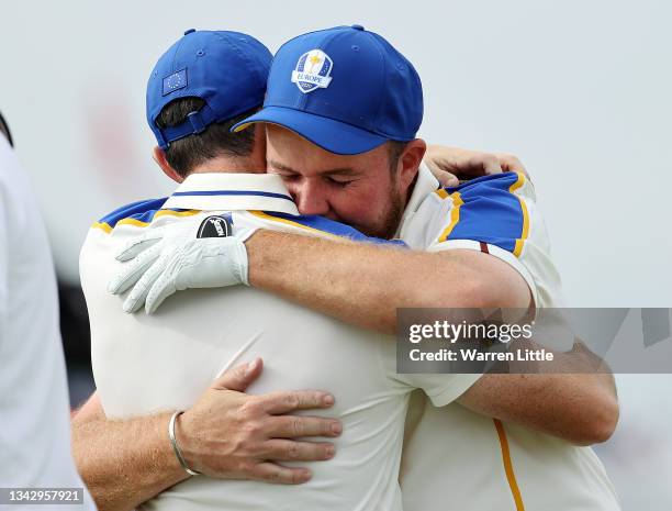 Shane Lowry of Ireland and team Europe hugs Rory McIlroy of Northern Ireland and team Europe on the 16th green after losing to Patrick Cantlay of...