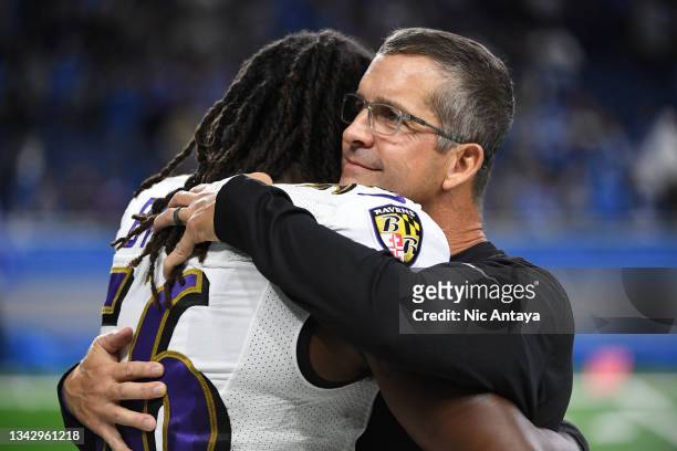 Head coach John Harbaugh of the Baltimore Ravens hugs Josh Bynes of the Baltimore Ravens after a win against the Detroit Lions at Ford Field on...