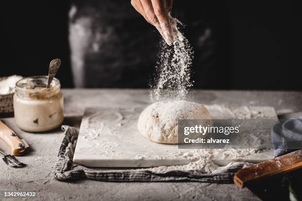 weibchen bereitet sauerteigbrot in der küche zu - streuen stock-fotos und bilder