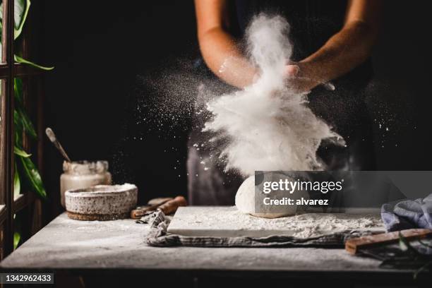 manos femeninas preparando pan de masa madre en la cocina - espolvorear fotografías e imágenes de stock