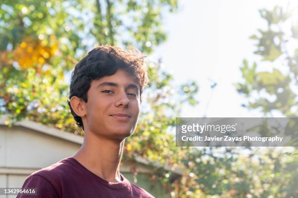 portrait of smiling teenage boy at back yard - spain teen face bildbanksfoton och bilder