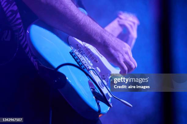 man artist musician playing the instrument guitar by hand during popular music rock concert - blues musician stock pictures, royalty-free photos & images