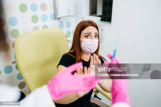 young woman getting vaccinated - needle stock pictures, royalty-free photos & images