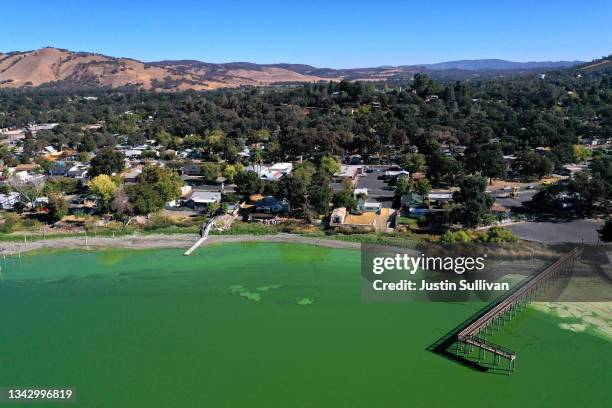 In an aerial view, blooms of cyanobacteria, also called blue-green algae, turn the water green in Clear Lake at Redbud Park on September 26, 2021 in...