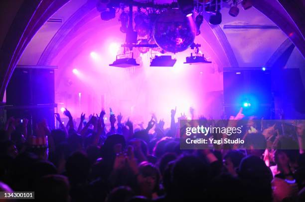 crowd with arms in air at nightclub music. - light club stock pictures, royalty-free photos & images