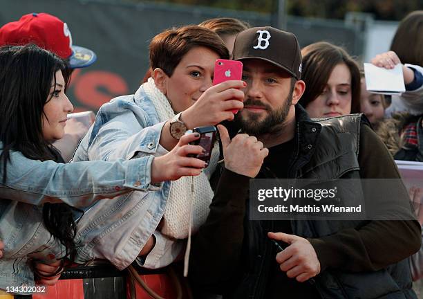 Factor Jury member Mirko Bogojevic takes photos with fans during The Dome 60 on November 30, 2011 in Duisburg, Germany.