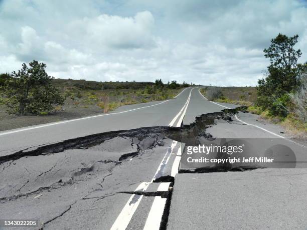 road fractured by volcanic eruption, crater rim drive, kilauea, hawai’i. - earthquake stock-fotos und bilder