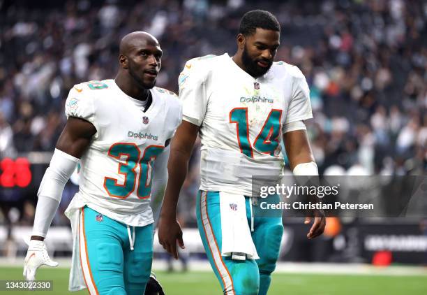 Jason McCourty and quarterback Jacoby Brissett of the Miami Dolphins walk to the locker room after losing the game in overtime to Las Vegas Raiders...