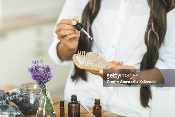 woman with long hair using serum for hair loss treatment. - aromatherapy oil stock pictures, royalty-free photos & images