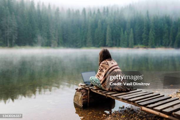 mujer relajándose en la naturaleza y usando la tecnología - remote location fotografías e imágenes de stock