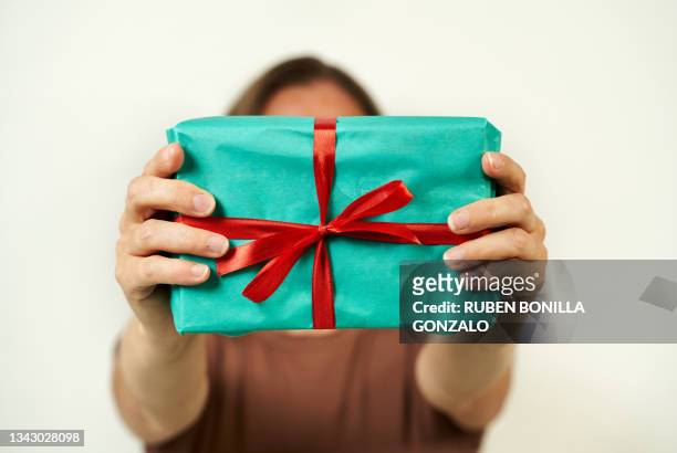woman showing a wrapped and tied bow at a present on white background. - lint strik stockfoto's en -beelden