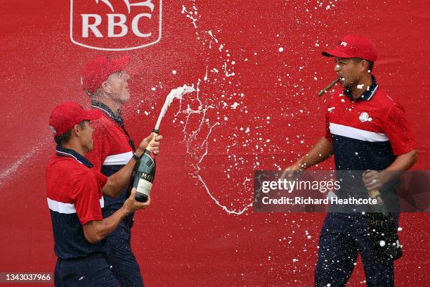 Xander Schauffele , Collin Morikawa, and vice-captain Jim Furyk of team United States celebrate with champagne after defeating team Europe during...