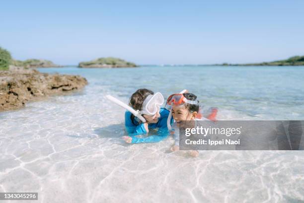 mother and child with snorkel mask in tropical beach water - tropical beach holiday stock pictures, royalty-free photos & images