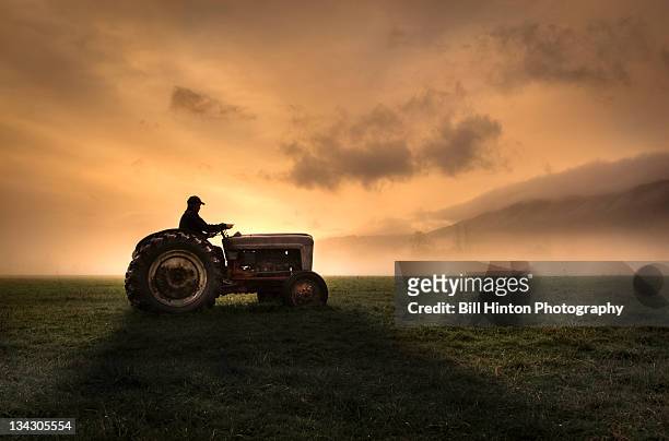 farmer riding tractor - agricultural equipment stockfoto's en -beelden