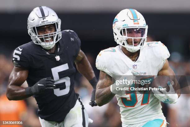 Running back Myles Gaskin of the Miami Dolphins rushes the football past linebacker Divine Deablo of the Las Vegas Raiders during overtime of the NFL...