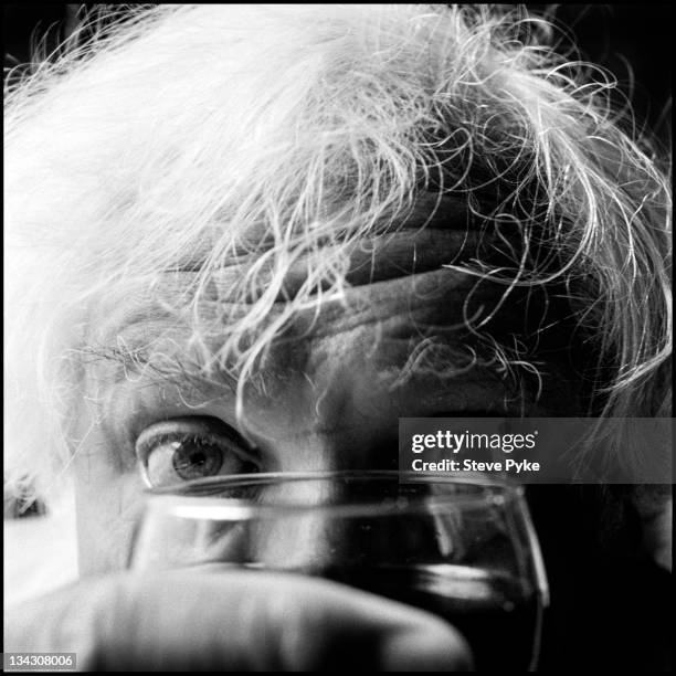 English film director Ken Russell , peering over a glass of wine, 19th August 1985.