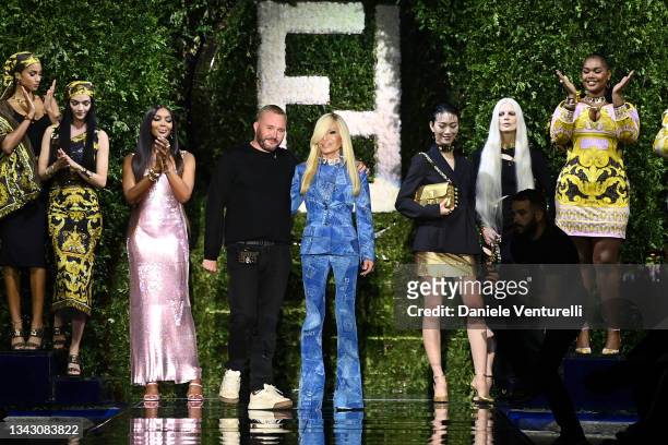 Maria Carla Boscono, Naomi Campbell, fashion designer Kim Jones and Donatella Versace acknowledges the applause of the audience at the Versace...