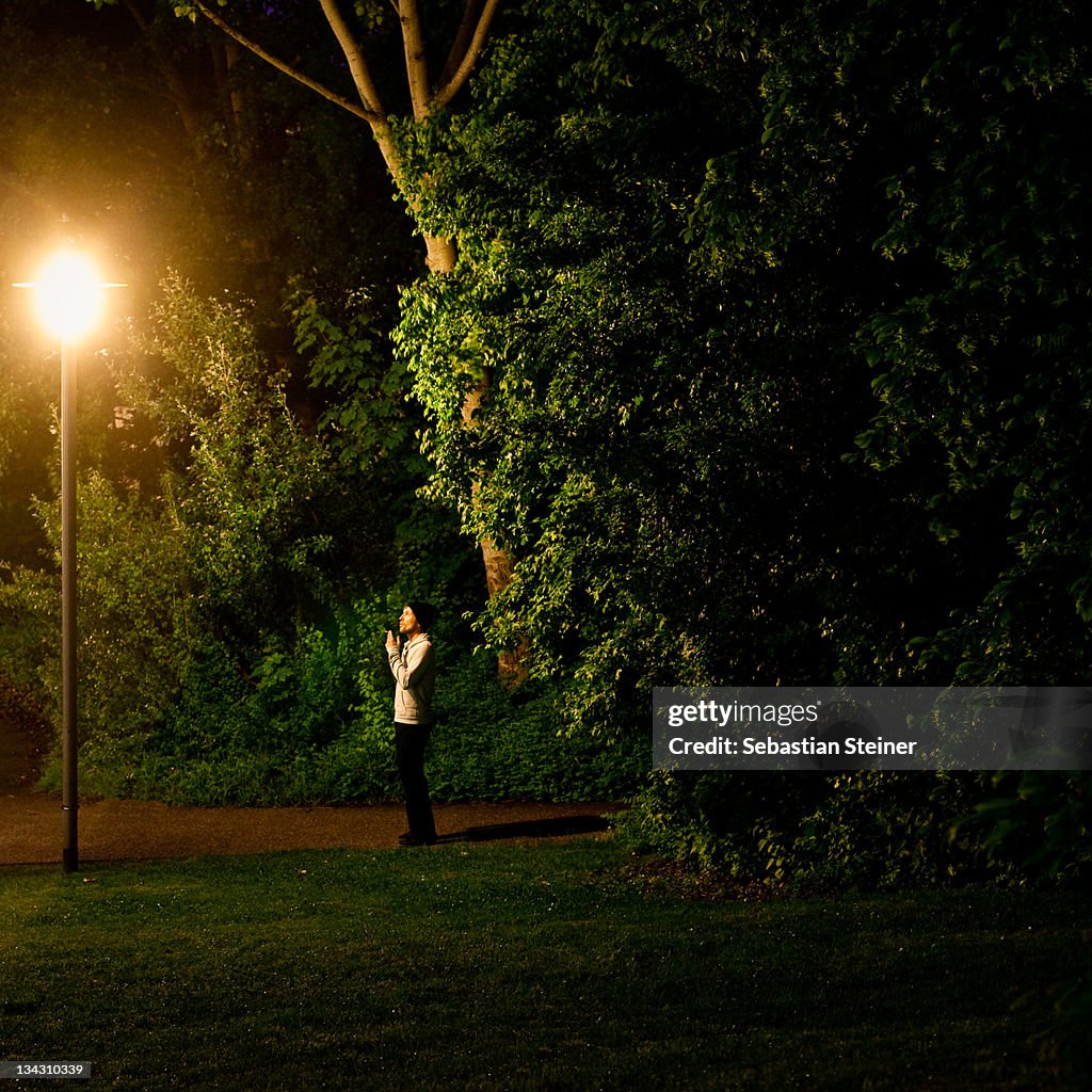 Man in warm clothes staring at street lamp