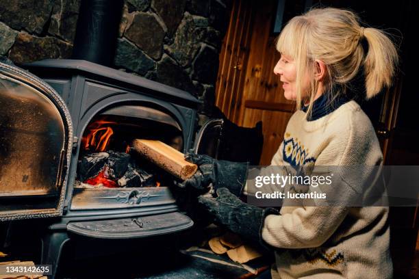 wood burning stove - stoking 個照片及圖片檔