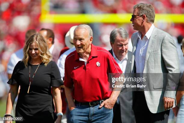 Former head coach Barry Switzer walks with former Oklahoma Sooners quarterback Troy Aikman after the first quarter of a game between the Sooners and...