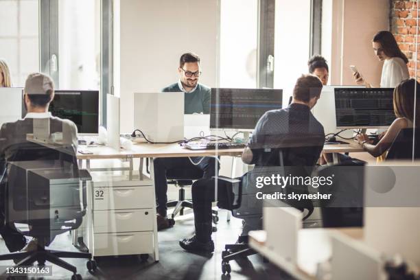grande grupo de programadores trabalhando em pcs de desktop no escritório. - code - fotografias e filmes do acervo