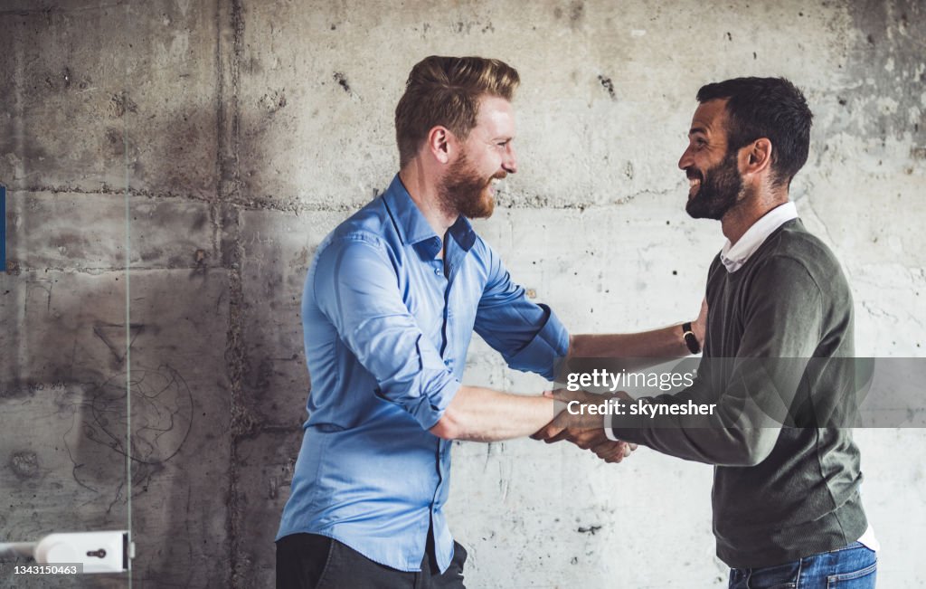 Happy businessmen greeting each other in the office.