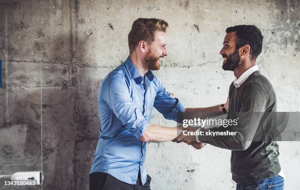 happy businessmen greeting each other in the office. - smart casual stock pictures, royalty-free photos & images